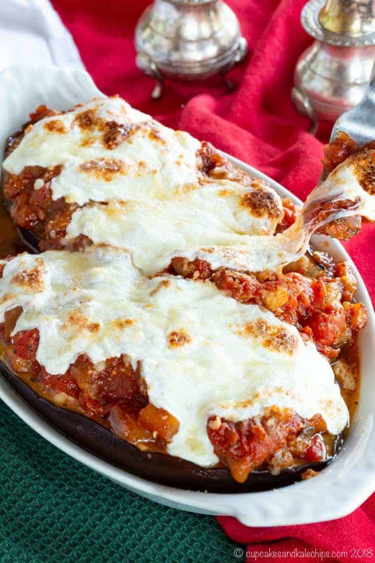 Taking a bite of Stuffed Eggplant parmesan with cheese pull