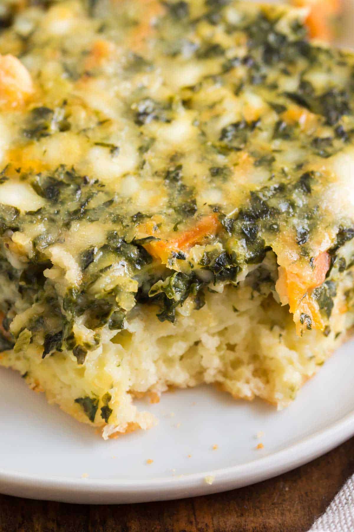 Closeup to see the spinach, carrots, and biscuit crust in the baked casserole.