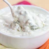 Spoon dipping into a bowl of Greek Yogurt Blue Cheese Dressing