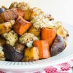 A bowl of balsamic roasted vegetables on red and white cloth napkins.