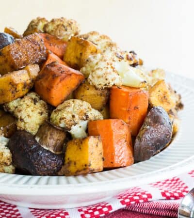 A bowl of balsamic roasted vegetables on red and white cloth napkins.