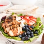 Grilled Chicken Berry Salad with Blueberry Maple Balsamic Vinaigrette with a fork resting in front of the bowl.