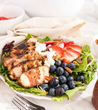 Grilled Chicken Berry Salad with Blueberry Maple Balsamic Vinaigrette with a fork resting in front of the bowl.