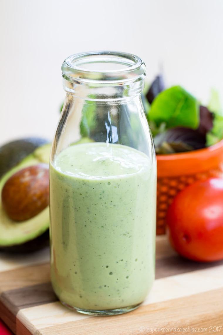 A glass bottle filled with homemade avocado ranch dressing