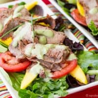 Avocado Ranch Steak Salad with Mango on white rectangular plates