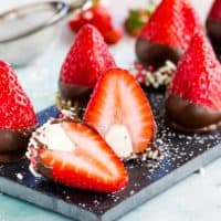 Platter of Chocolate Covered Cheesecake Strawberries with one cut open