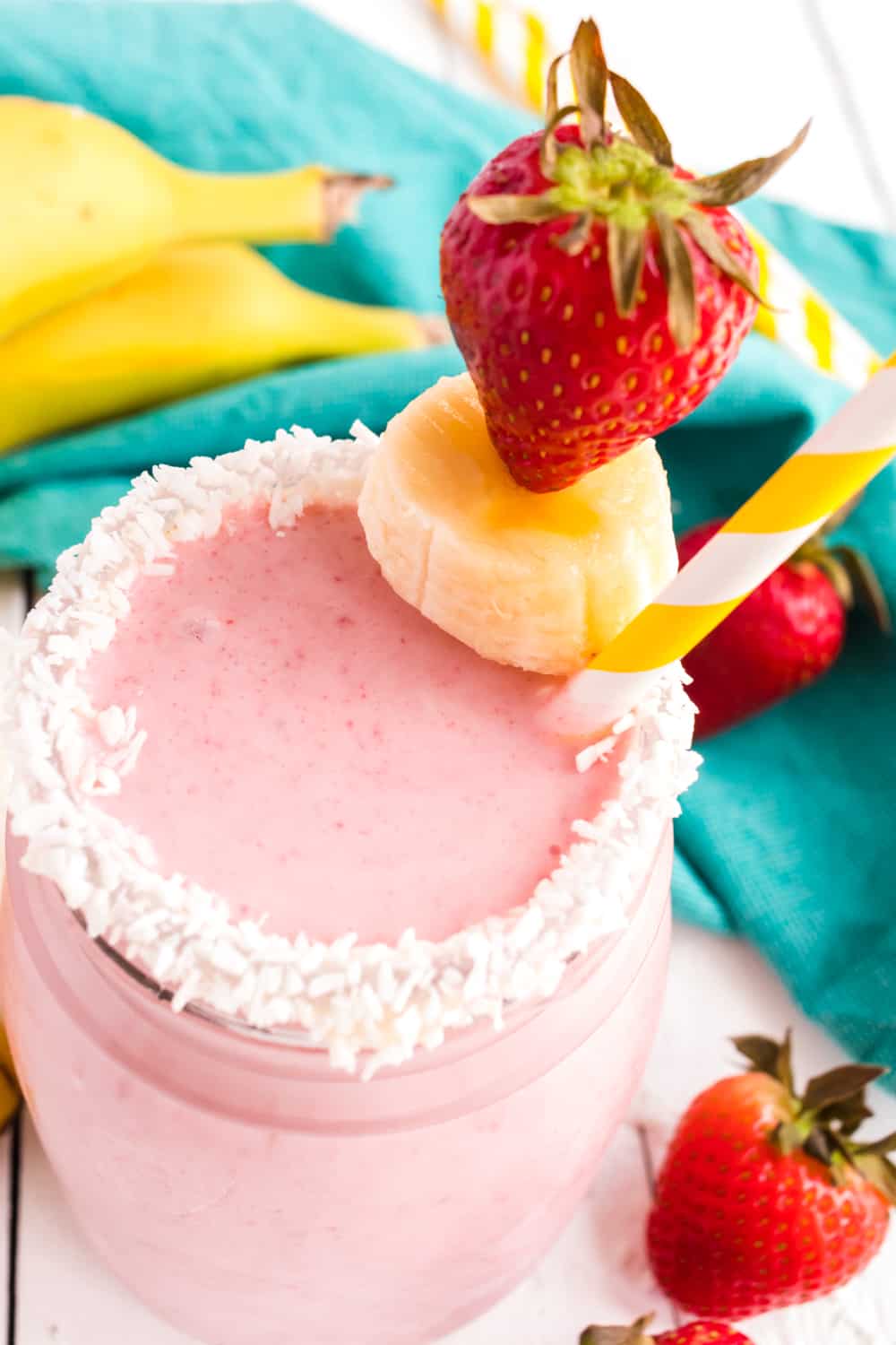 Closeup of Strawberry Banana Coconut Smoothie in a garnished glass.