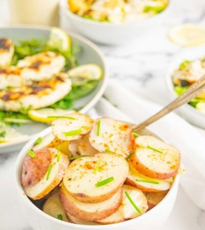 A bowl of Foil Packet Potatoes on a table with other dishes.