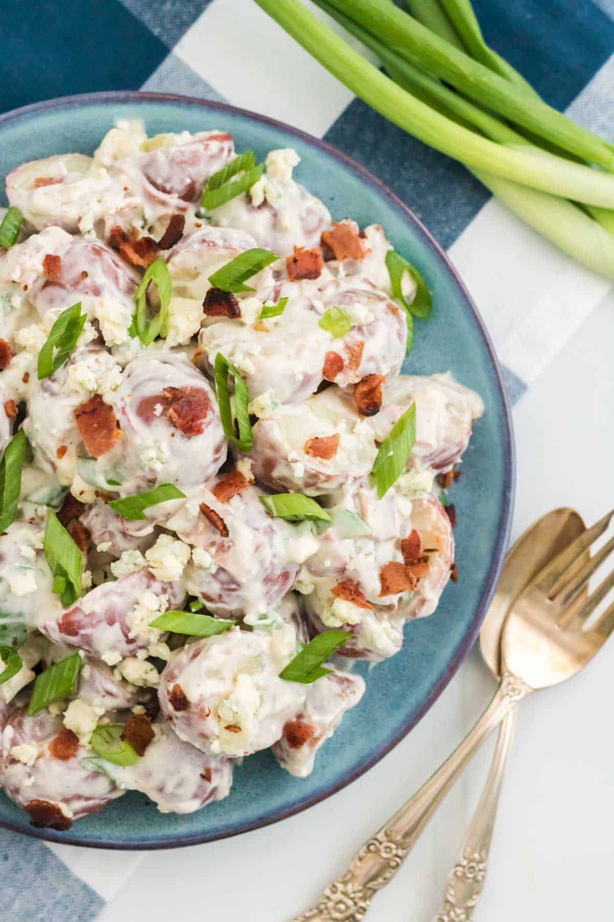 Blue cheese bacon potato salad on a plate next to a fork.