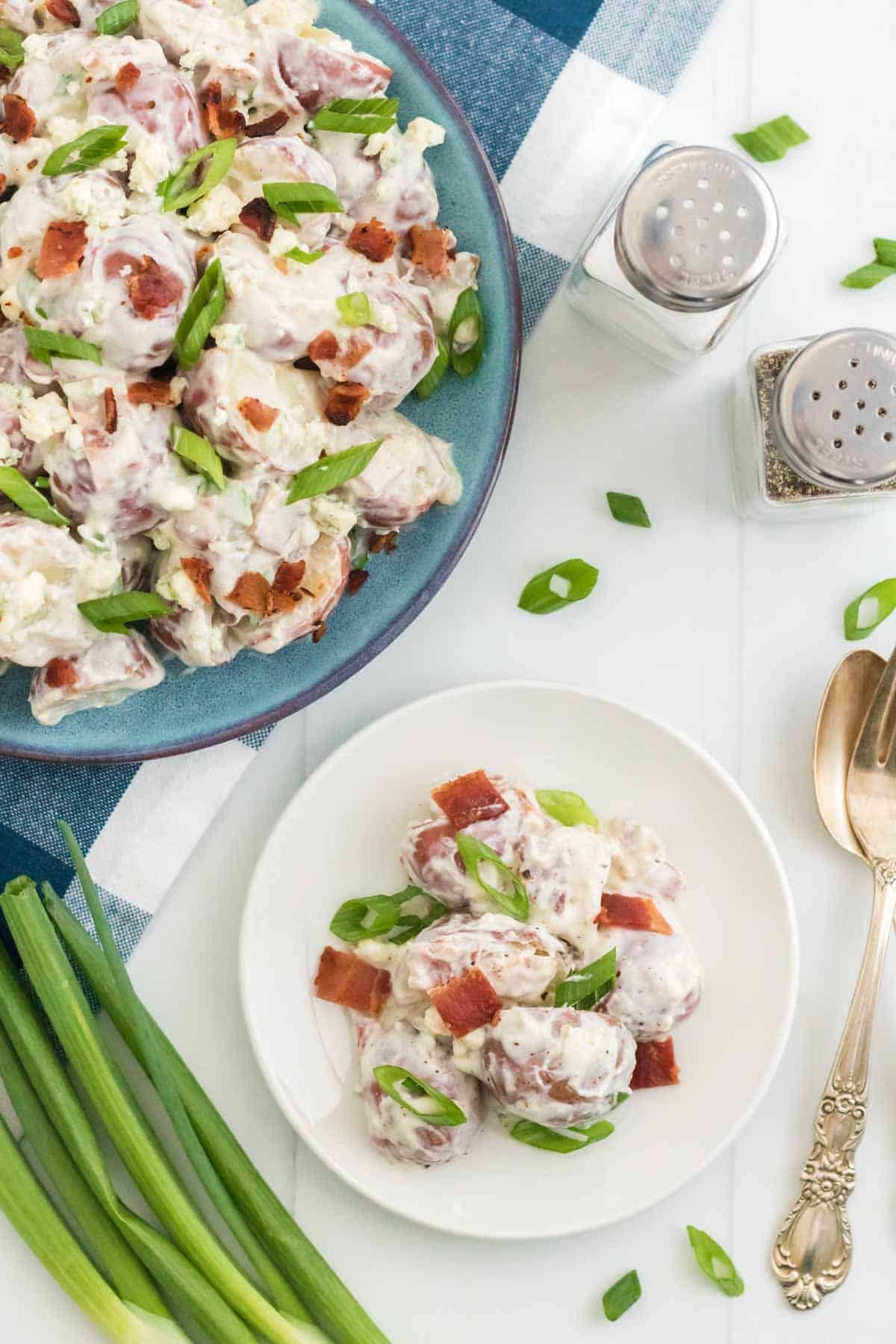 A small plate of bacon potato salad next to the remaining salad.