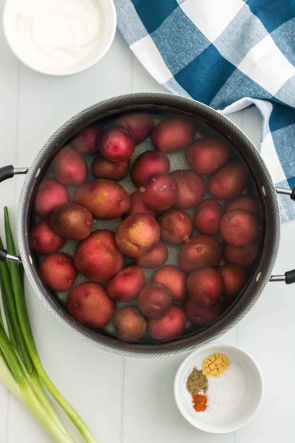 Red potatoes in a pot of water.