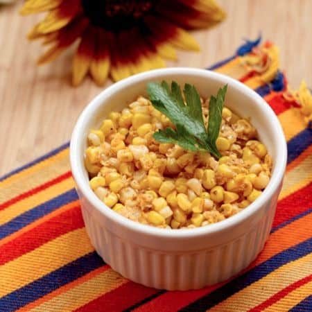 Chili lime corn kernels in a ramekin garnished with cilantro.