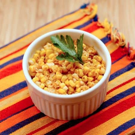 Chili lime corn kernels in a ramekin garnished with cilantro.