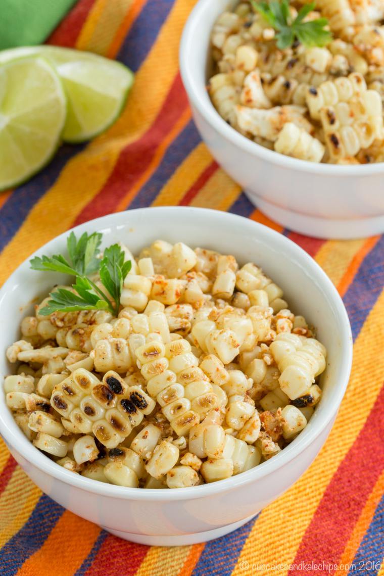 Two bowls of charred chili lime corn kernels garnished with cilantro.