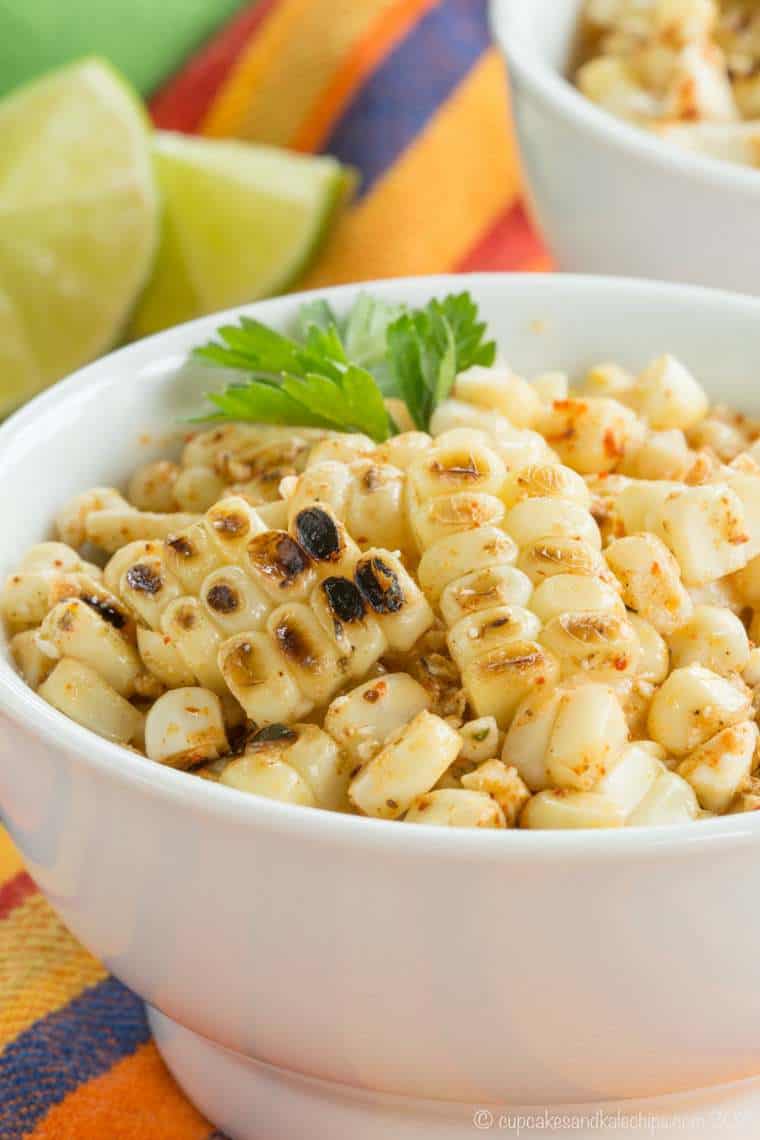 A bowl of charred corn kernels garnished with cilantro.