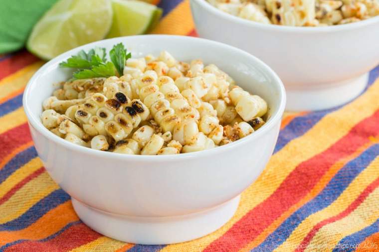 A bowl of charred chili lime corn kernels garnished with cilantro.