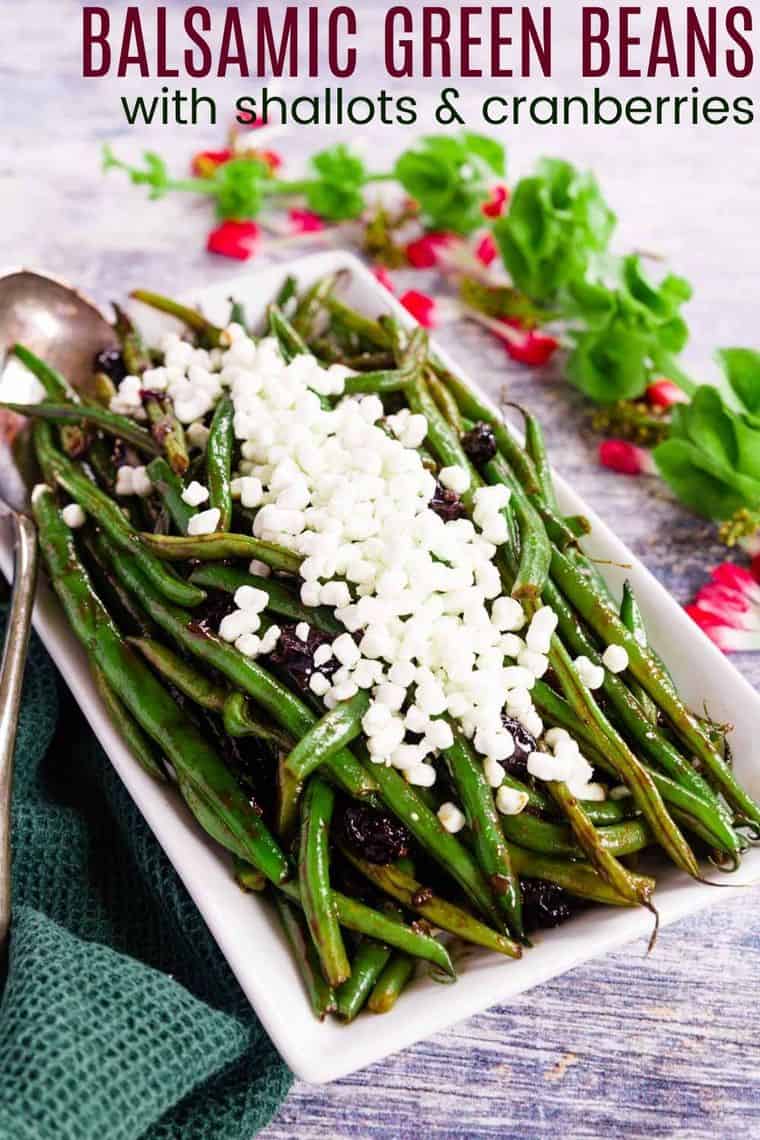 A serving platter with Balsamic Green Beans with Cranberries and crumbled goat cheese on top