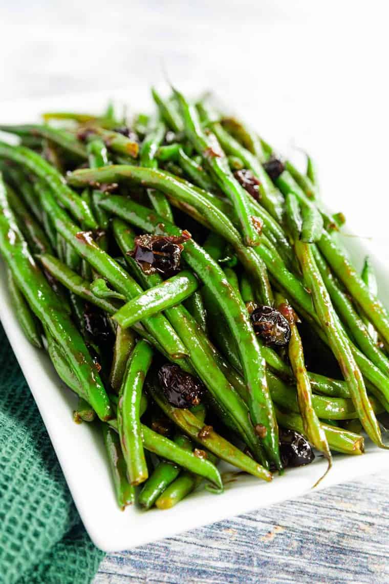 Balsamic Glazed Green Beans with Dried Cranberries piled on a white plate