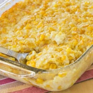 A serving spoon in a corn pudding casserole.