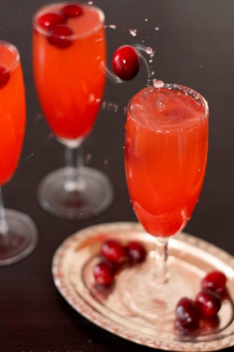 Dropping fresh cranberries into a Cranberry Fizz Mocktail