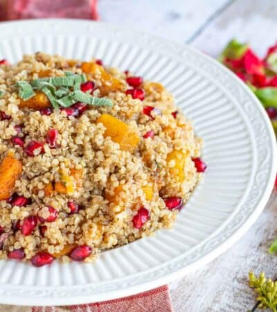 Bowl of butternut squash and pomegranate quinoa topped with sage