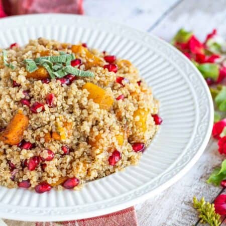 Bowl of butternut squash and pomegranate quinoa topped with sage