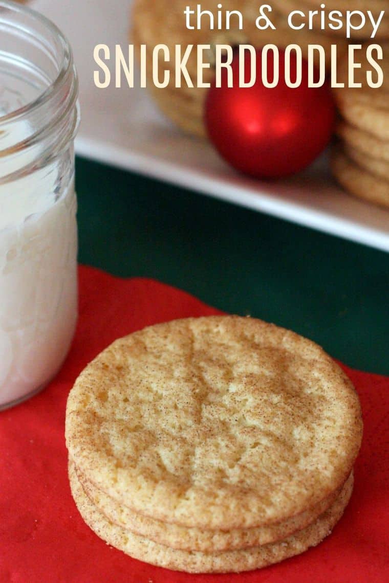 Stacked snickerdoodles on a red napkin with a glass of milk