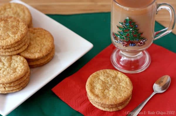 Snickerdoodles on a white plate with three on a red napkin with a cup of tea