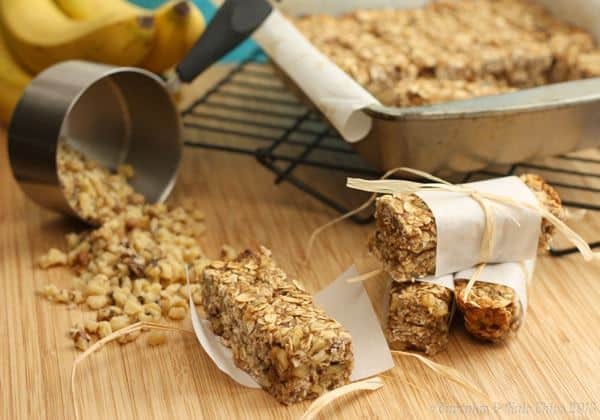 Banana nut breakfast granola bars next to a oats spilling from a measuring cup.