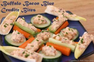 Crudites topped with bacon blue cheese buffalo dip arranged on a plate.