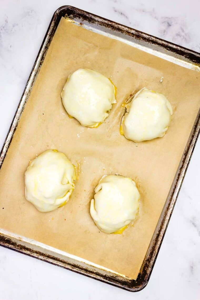 Individual beef wellingtons on a baking sheet