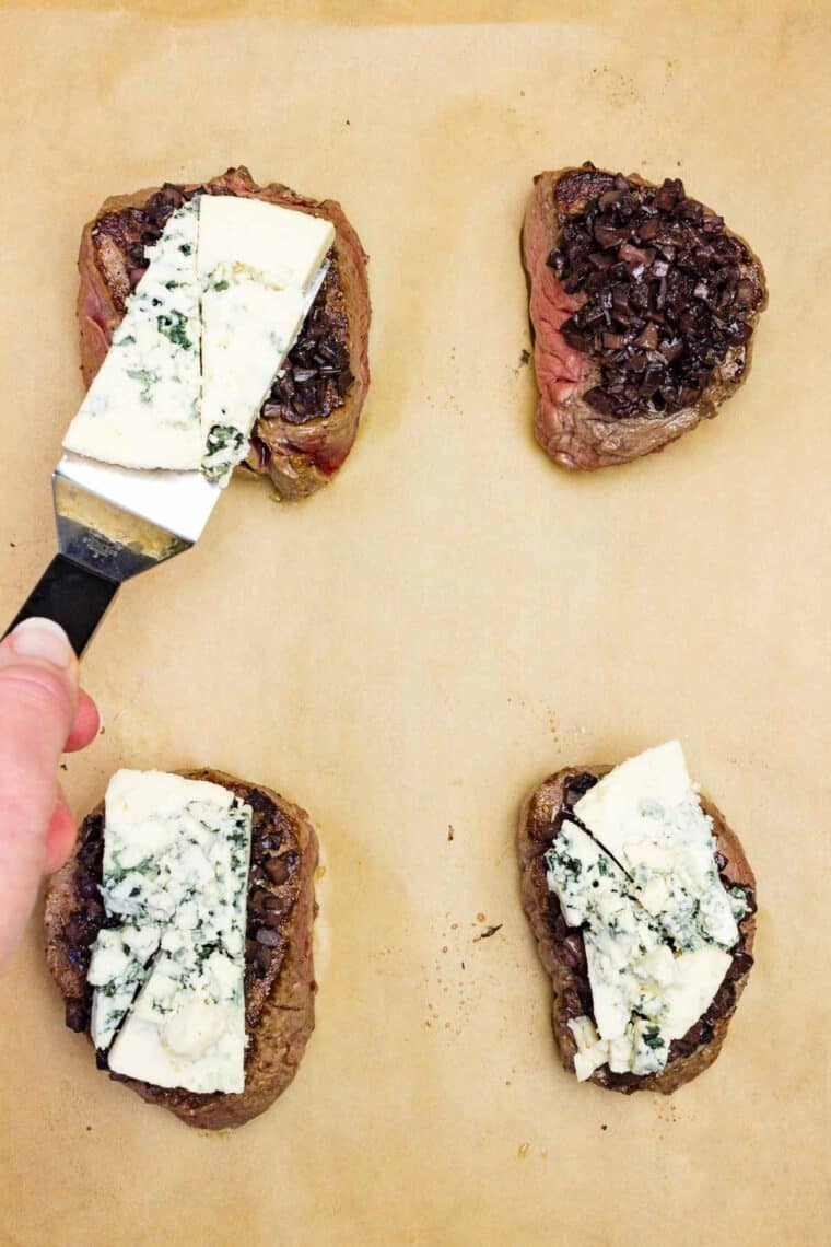 Placing blue cheese on top of mushroom duxelle on top of seared filet mignon