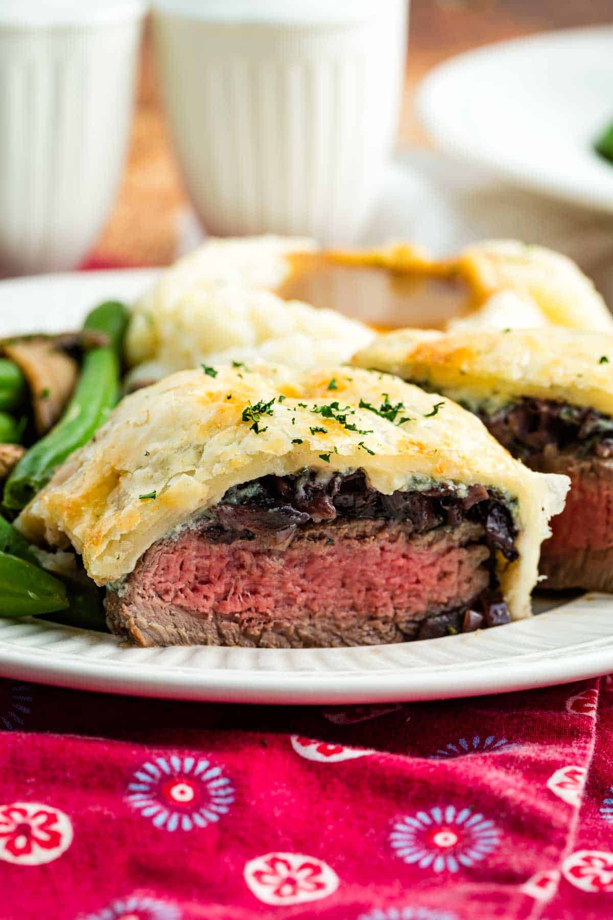 Individual Beef Wellington cut in half to show the medium rare steak inside