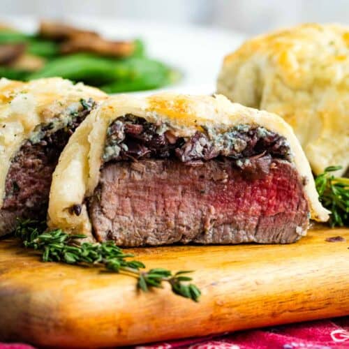 Individual Beef Wellingtons on a cutting board showing the inside