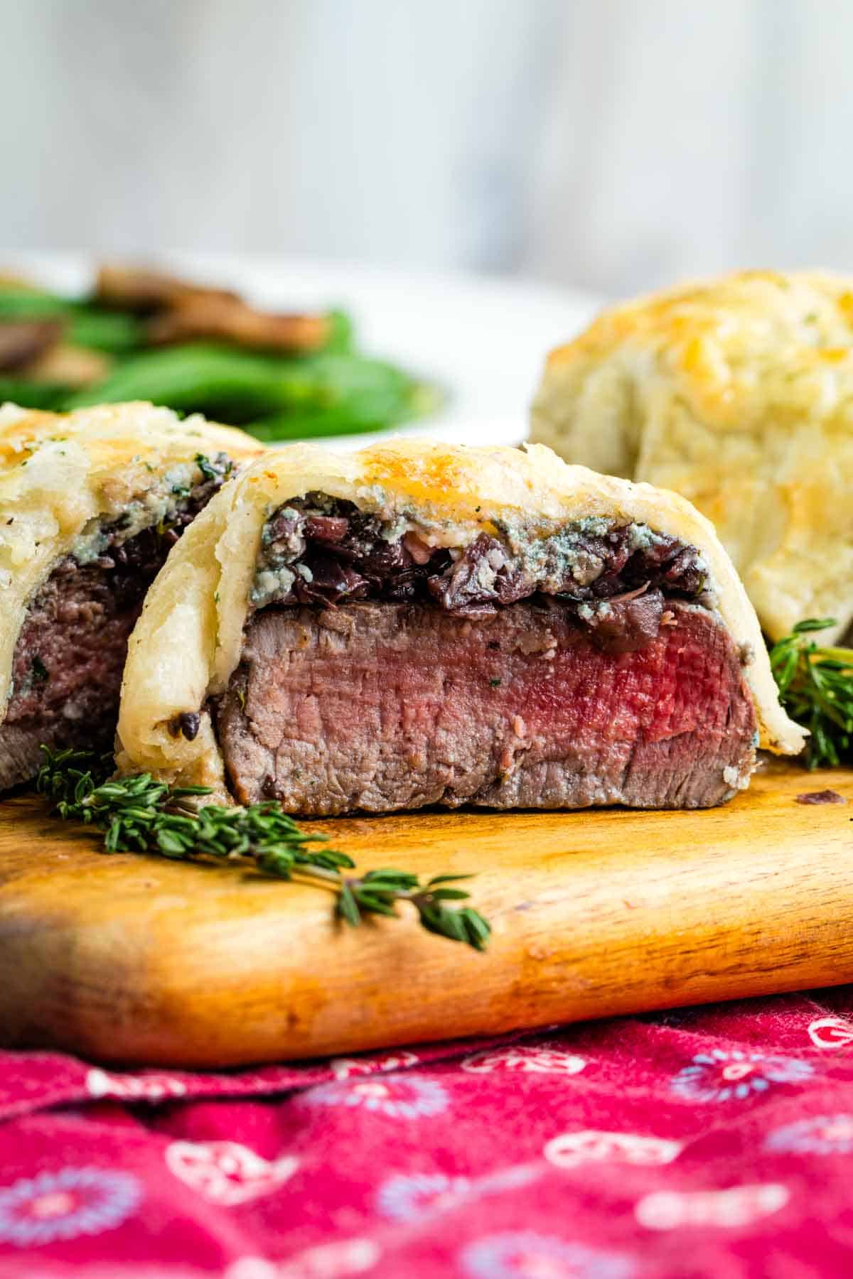 Individual Beef Wellingtons on a cutting board showing the inside