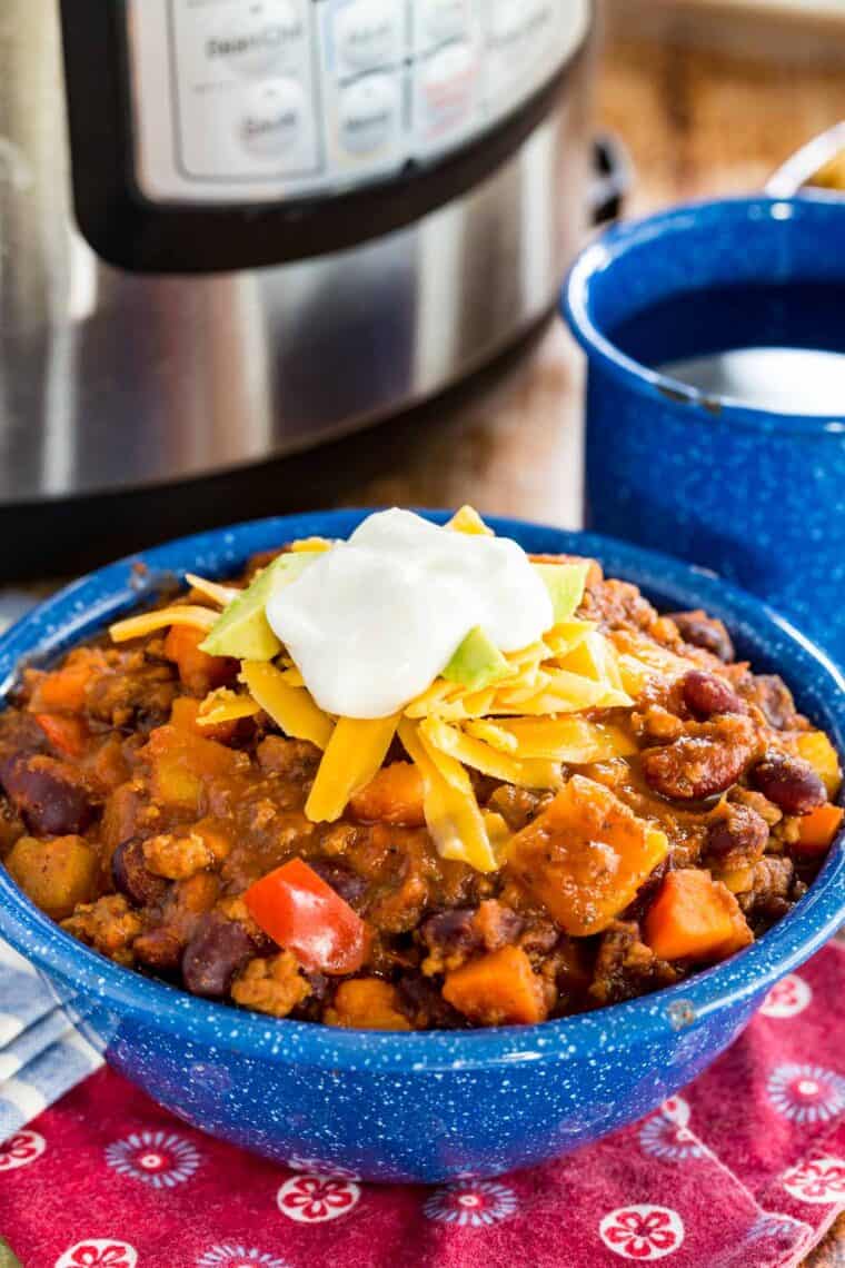 A bowl of Instant pot chili topped with shredded cheese and sour cream.