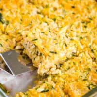 Scooping up a piece of zucchini rice casserole out of the baking dish