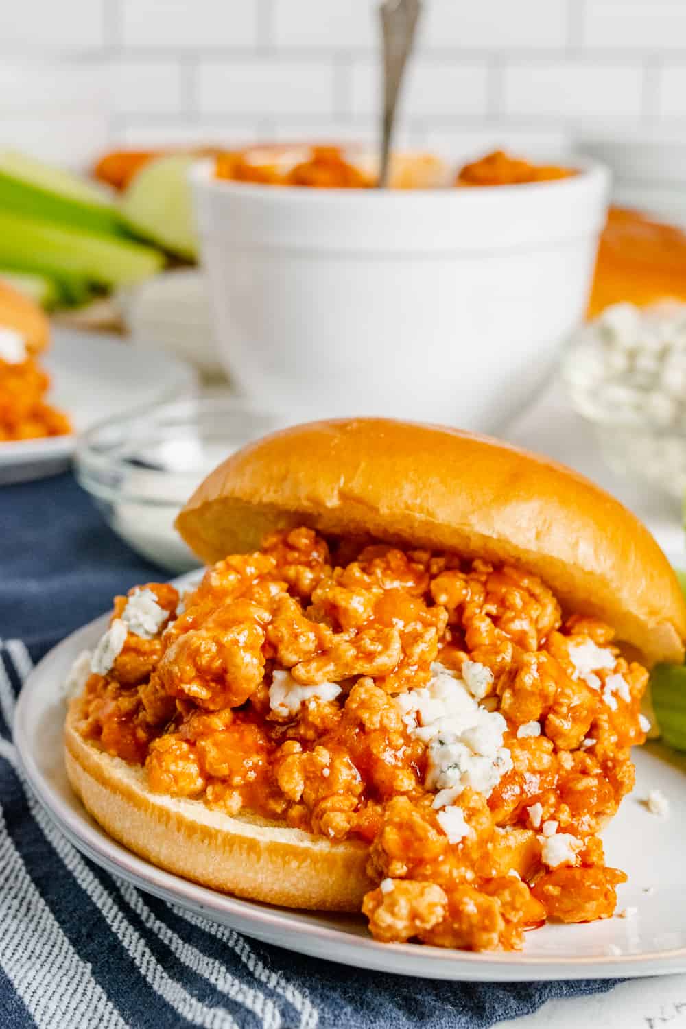 Buffalo chicken sloppy joes sandwich on a bun with crumbled blue cheese.