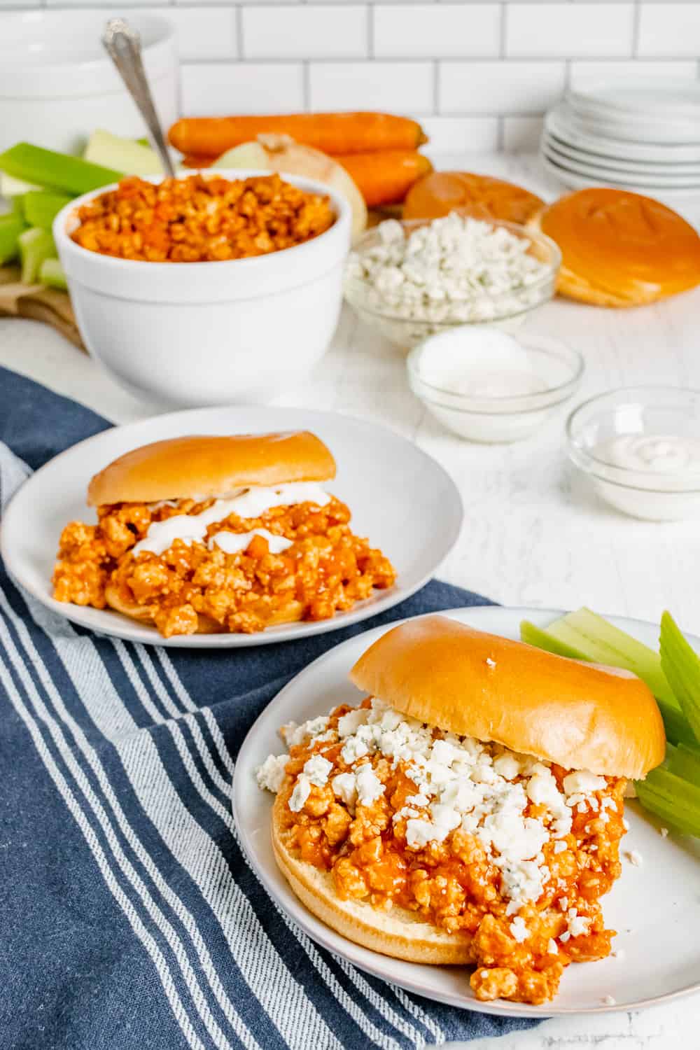 Two Buffalo Chicken Sloppy Joe Sandwiches one with blue cheese on top and the other with ranch dressing