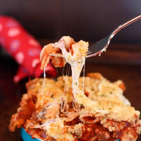 A fork picking up a cheesy bite of Baked Eggplant Parmesan Pasta