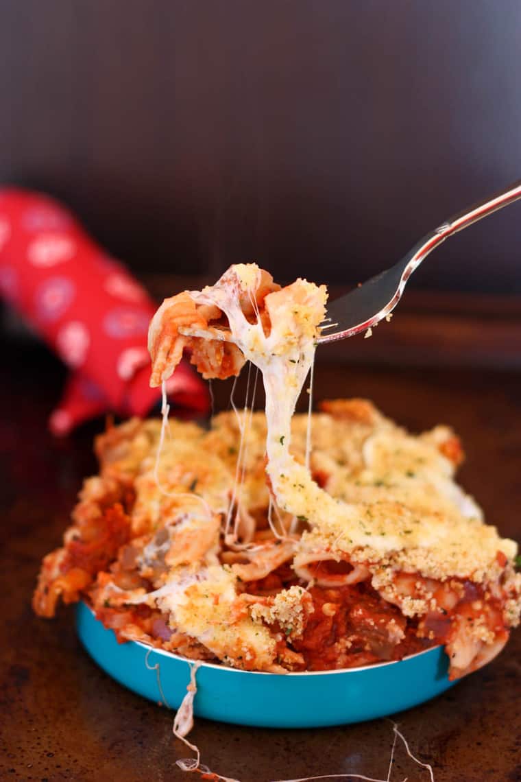 A fork picking up a cheesy bite of Baked Eggplant Parmesan Pasta