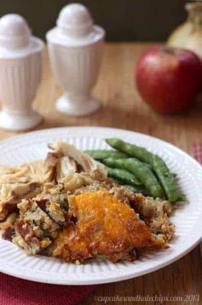 A plate with turkey, green beans, and apple, bacon, cheddar cheese gluten-free stuffing.