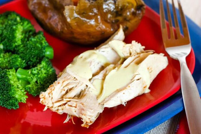 Pieces of Crock Pot Turkey Breast with sauce on a red plate