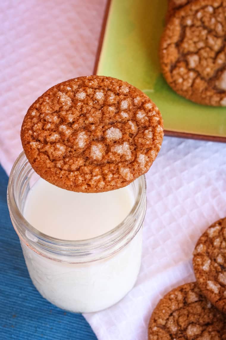 Gingersnap cookie balanced on a glass of milk