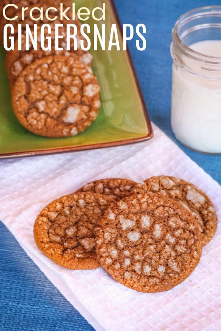 Gingersnap cookies on a white napkin with a glass of milk