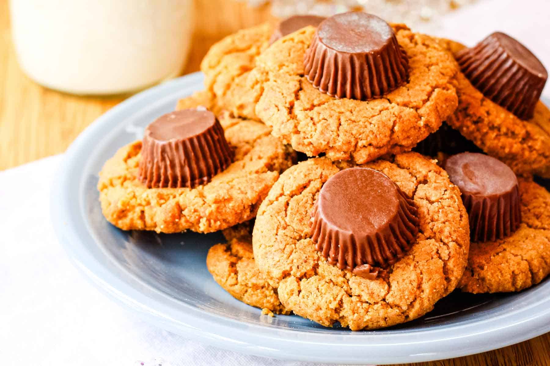 A blue plate of peanut butter cookies topped with Reese's peanut butter cups.