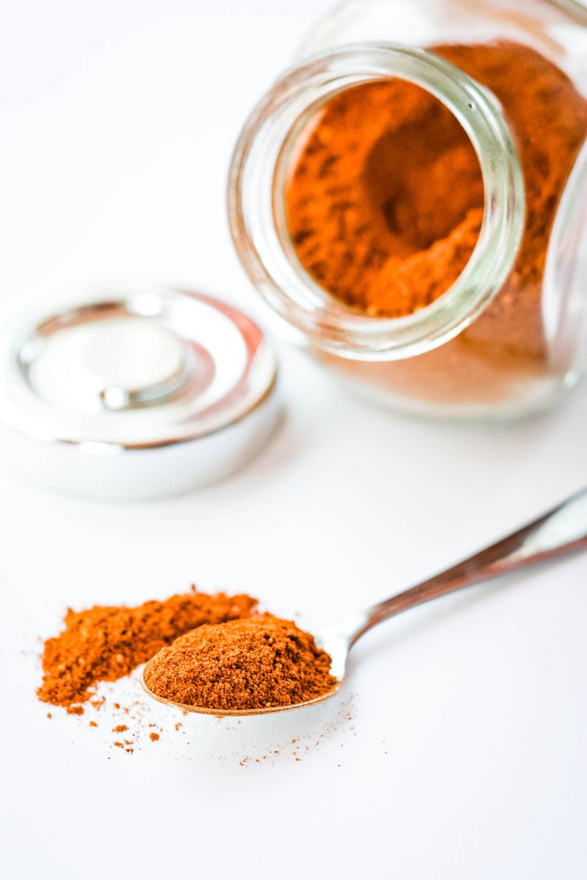 Mexican Chocolate Spices on a spoon with a jar in the background.