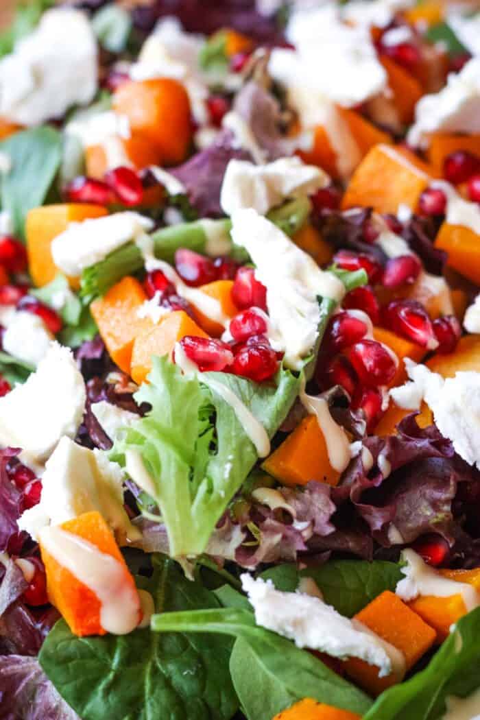 Mixed spring greens with cubed of butternut squash, pomegranate arils, and crumbled goat cheese