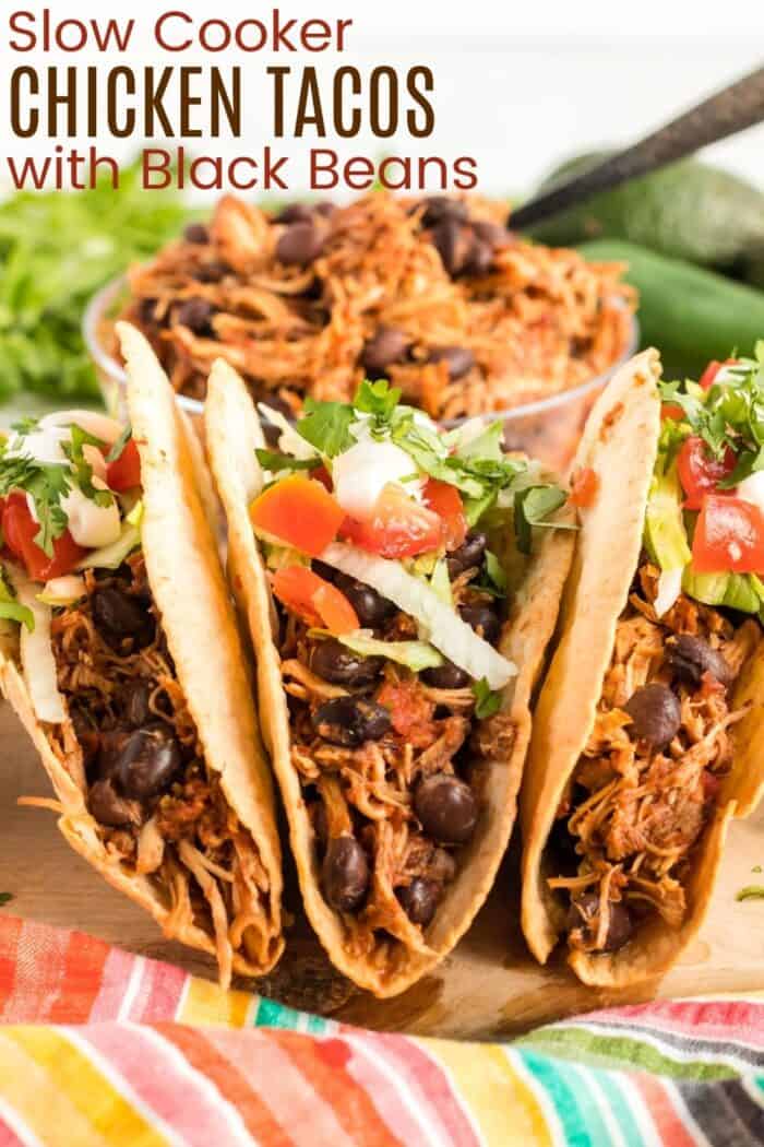 Three chicken and balck bean tacos standing up