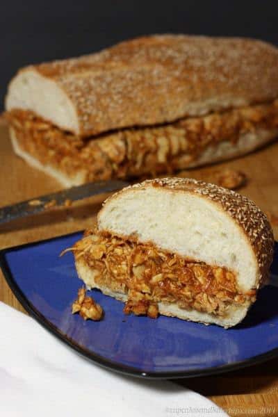 A barbecue chicken sandwich on a blue plate.